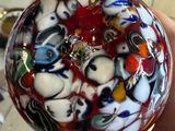 a person holding a glass ball with a lot of colorful designs on it