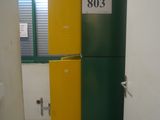 un casier vert et jaune dans une salle de bains, près d'une fenêtre