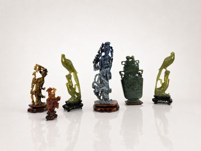 four different colored vases sitting on top of each other on a white surface