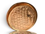a gold case with a clock inside of it on a white surface