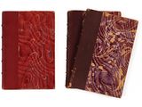 deux carnets en cuir rouge ornés de motifs complexes