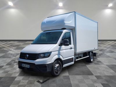 La camionnette blanche est garée sur un sol à damier, dans une grande pièce.