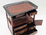 a small wooden chest of drawers with a tray on top