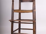 une chaise haute en bois avec une assise tressée sur fond blanc