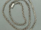 une image représentant une chaîne en argent avec un fermoir en argent sur un fond gris