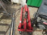 une photo d'une machine rouge posée au sommet d'un tas de ferraille
