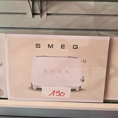 un grille-pain blanc posé sur une étagère dans un magasin