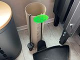 a black trash can and a black trash can next to a radiator