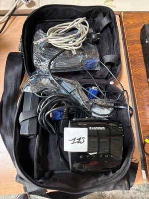 a bag of electronics sitting on a table next to a laptop