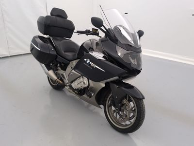 une moto noire garée dans une pièce aux murs blancs