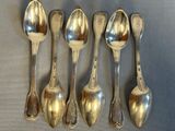 six spoons are lined up in a row on a table