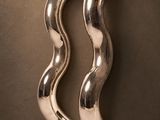 sculpture en métal argenté représentant une vague incurvée sur fond marron