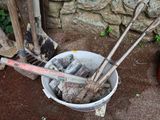 un seau rempli d'outils posé à côté d'un tas de bois de chauffage