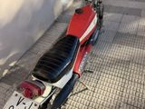 a red and white motorcycle parked on the sidewalk