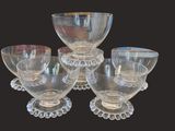 six bols et tasses en verre transparent sont posés sur une table