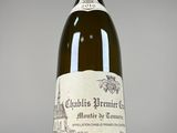 an old bottle of wine sitting on top of a white table