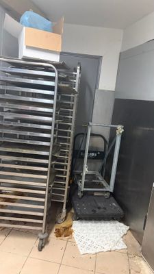 several trays of food sit on a rack in a kitchen