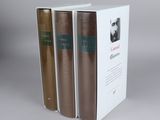three books are stacked on top of each other on a table