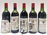 quatre bouteilles de vin sont alignées sur une surface blanche