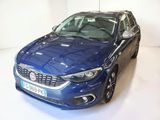 La voiture bleue est garée sur le sol blanc de la pièce.