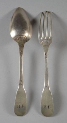 deux cuillères et une fourchette en argent sur une table