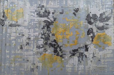 une photo d'un tapis orné de motifs jaunes et gris