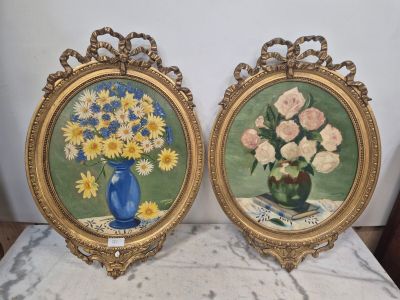 une paire de tableaux représentant des fleurs dans un vase bleu posé sur une table