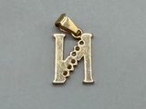 a close up of a gold charm with the letter n on it