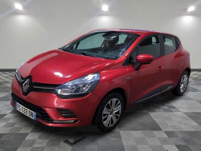 une voiture rouge garée sur le sol en damier d'un garage