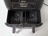 a picture of an air fryer with two trays of food in it
