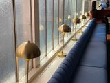 a long blue couch sitting in front of a window next to a blue couch
