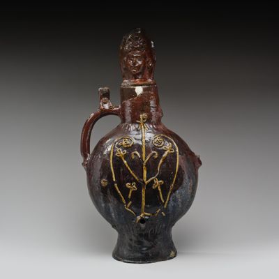 une photo d'un vase marron et noir posé sur une table