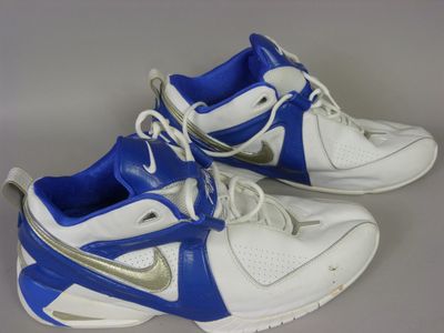 pair of white and blue sneakers with silver accents on a gray surface