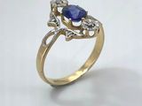 a close up of a gold ring with a blue stone and diamonds