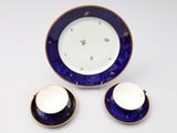 trois pièces de porcelaine bleue et blanche ornées de bordures dorées