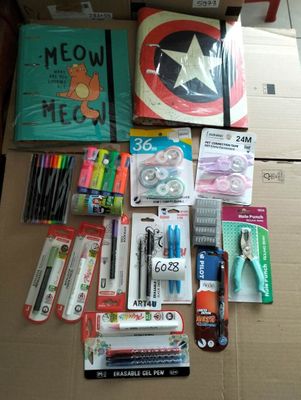 a cardboard box filled with school supplies and pens