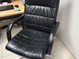 a black office chair sitting in front of a computer desk