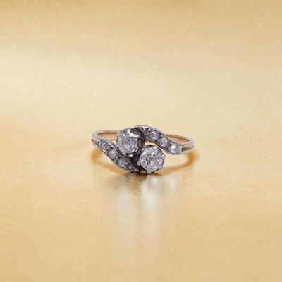 un gros plan d'une bague en diamant posée sur une surface en or
