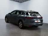 the back of a grey car is parked in a large room