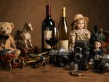 des bouteilles de vin, un ours en peluche, un petit train et une bouteille de vin posés sur une table en bois
