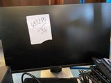 a black computer monitor sitting on a desk next to a keyboard and mouse