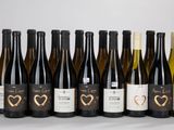 six bouteilles de vin sont alignées sur une table