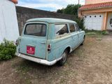 an old blue car parked in front of a house