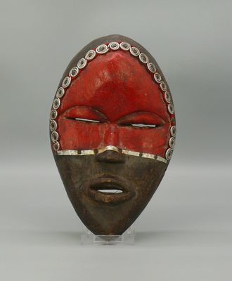 un gros plan d'un masque en bois au visage rouge