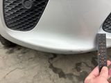 a person holding a measuring tape in front of a car