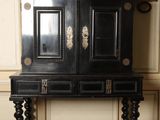 a black cabinet with a mirror on top of it