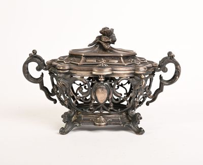 un plat ancien en argent orné d'un oiseau, posé sur un socle