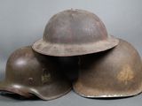 three helmets are stacked on top of each other on a gray surface