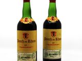 two bottles of wine sitting next to each other on a white surface
