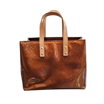a brown leather handbag with a star design on the front